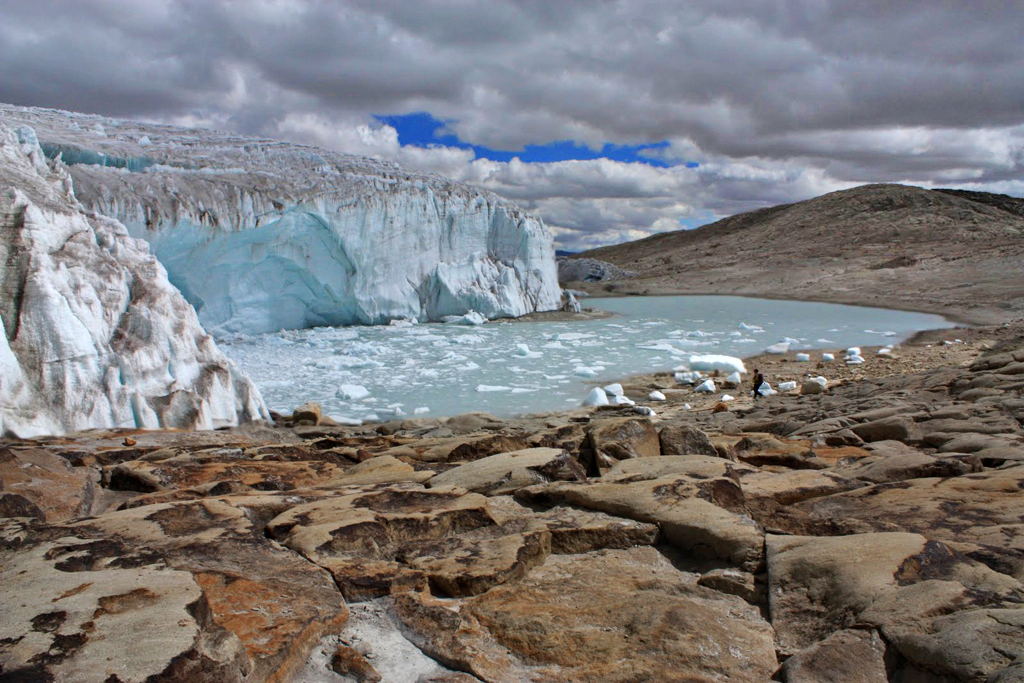 Stunning glacial landscape at Qelqaya near Cuzco, featuring ice formations, a glacial lake, and a solitary figure. Machupi...
